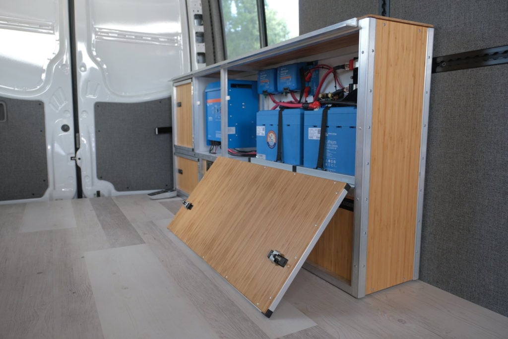 wooden cabinetry in back of van with blue power boxes inside
